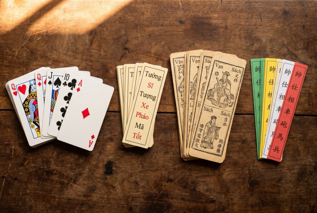 Four Vietnamese card decks side by side: a Western 52-card pack, the 32-card Tam Cuc deck, the 120-card To Tom deck and the four-colour Tu Sac deck.