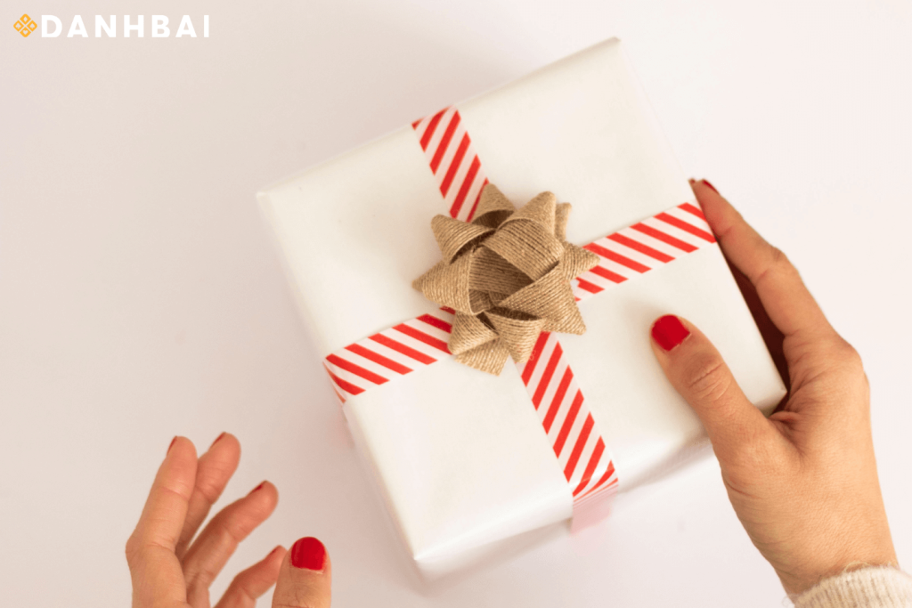 Một người đang cầm một món quà được gói.